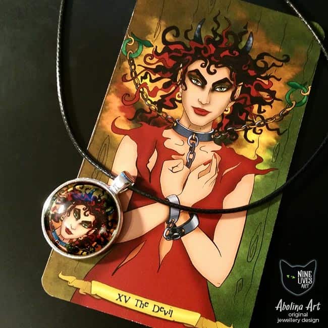 Devilish art pendant displayed with tarot card