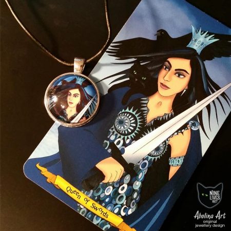 25mm Queen of Swords art pendant displayed with tarot card showing artwork reference