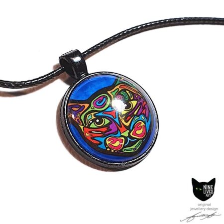 Bold colourful cat on turquoise background sealed under glass cabochon and strung on cord