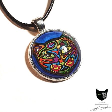 Bold colourful cat on turquoise background sealed under glass cabochon and strung on cord