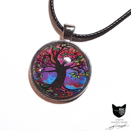 Gorgeous tree of life art pendant featuring bright pink and purple hues accentuated by splashes of blue - artwork sealed under glass cabochon and strung on cord for wearing