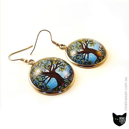 French hook style earrings featuring tree of life on blue background