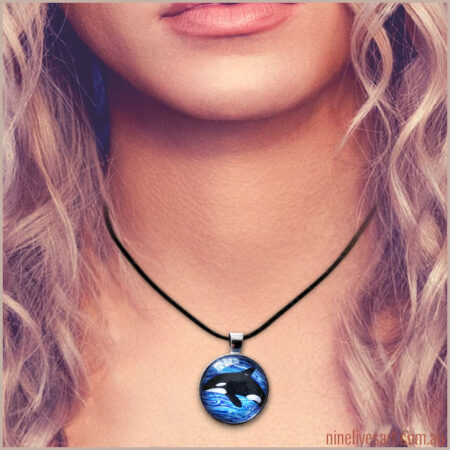 Model wearing pendant with Orca on ocean background
