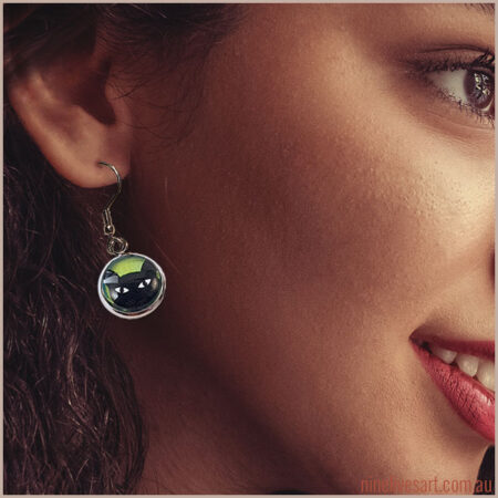 Model wearing 12mm black cat earrings - French hook style