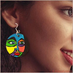 Model wearing hand-painted earring featuring bold and colourful face
