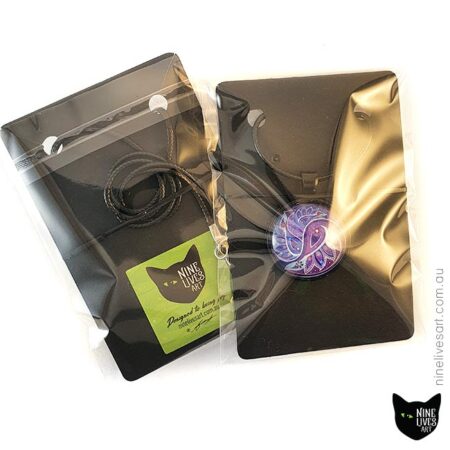 Clear jewellery packaging showing paisley pendant in purple colours