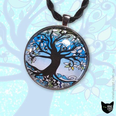 Tree of Life pendant strung on cord displayed on a faint blue background with tree artwork