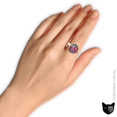 Model wearing 12mm cabochon ring with Paisley artwork in flamingo and blue colours