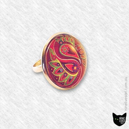 Front side view of 25mm cabochon ring featuring paisley artwork in magenta and lime