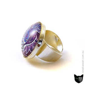 Side view of 25mm cabochon ring featuring paisley artwork in purple