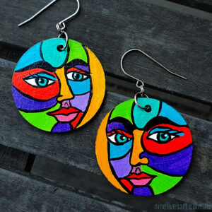 Bright faces hand-painted on 40mm timber discs assembled with French hooks