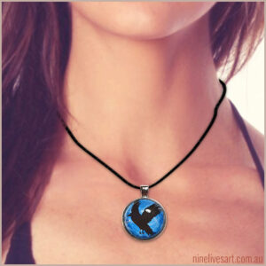 Model wearing 25mm glass dome pendant depicting a black raven flying against blue sky