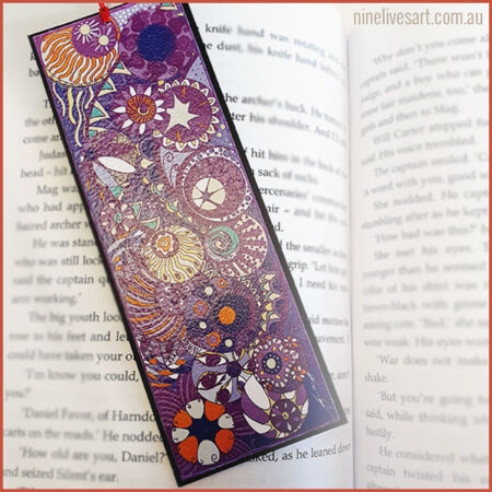 Colourful art bookmark featuring line drawing of circles painted in purple hues